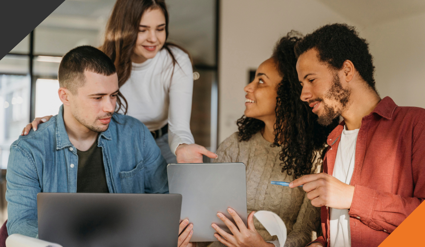 4 employees gathered around a desk overcoming stress and building resilience