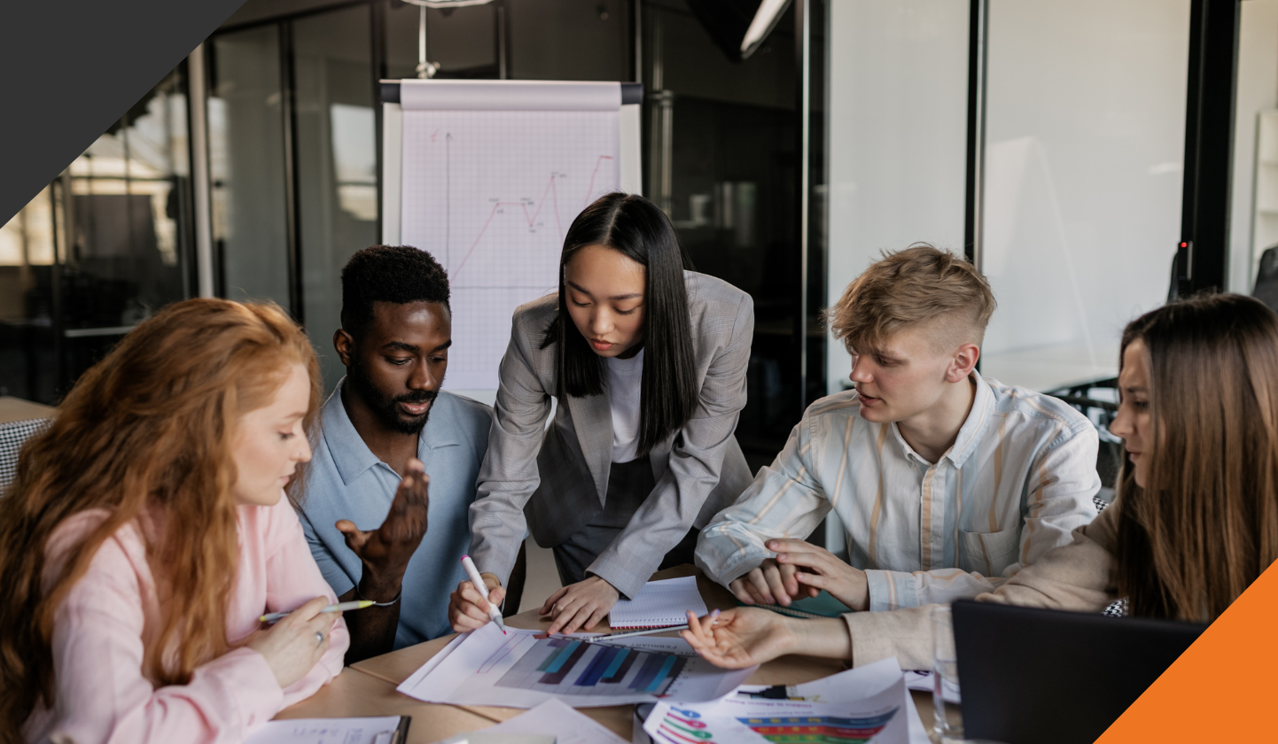 5 employees in a circle around a meeting table operating with a focus on team resilience