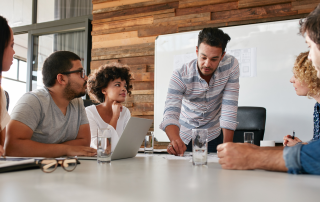 a leadership trainer addresses 4 employees on the 7 training strategies for unprecedented growth