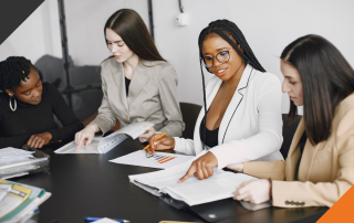 4 employees in seated around a meeting table discussing the path to cultural transformation i