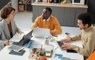 3 members of a leadership team practicing year-end team collaboration